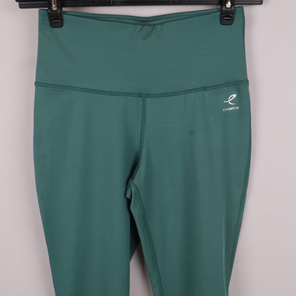 Närbild på midja och logga på gröna träningstights