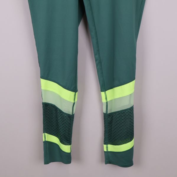 Närbild på neon- och meshdetaljer på benen på tightsen