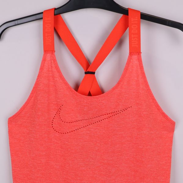 Närbild av framsidan på orange sporttopp med prickad Nike-logga