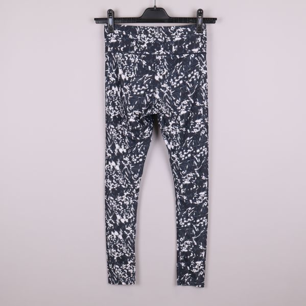 Baksida av svartvita mönstrade träningstights på galge