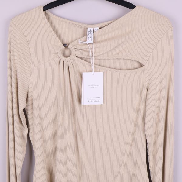 Övre delen av ljusbeige topp med ringdetalj