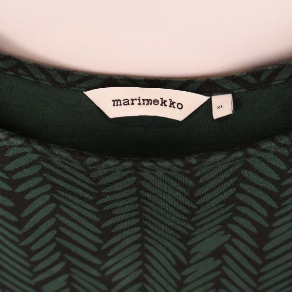 Närbild på Marimekko etikett och storlekslapp XL i halsen