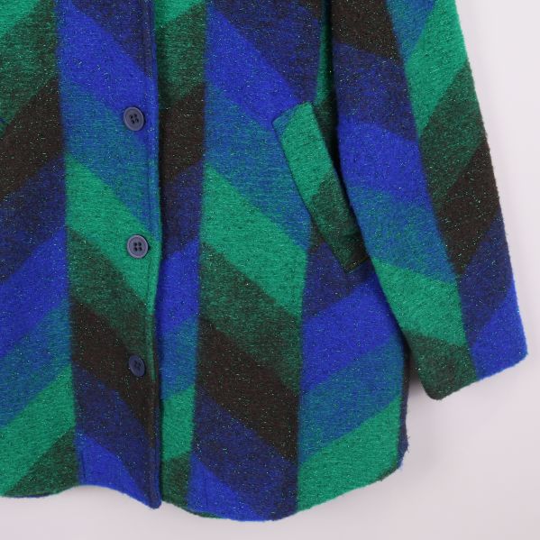 Närbild på ficka och tyg med tydligt mönster på jackan