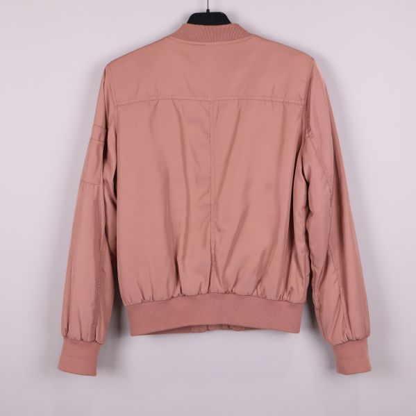 Baksidan av gammelrosa bomberjacka med ribbad nederkant