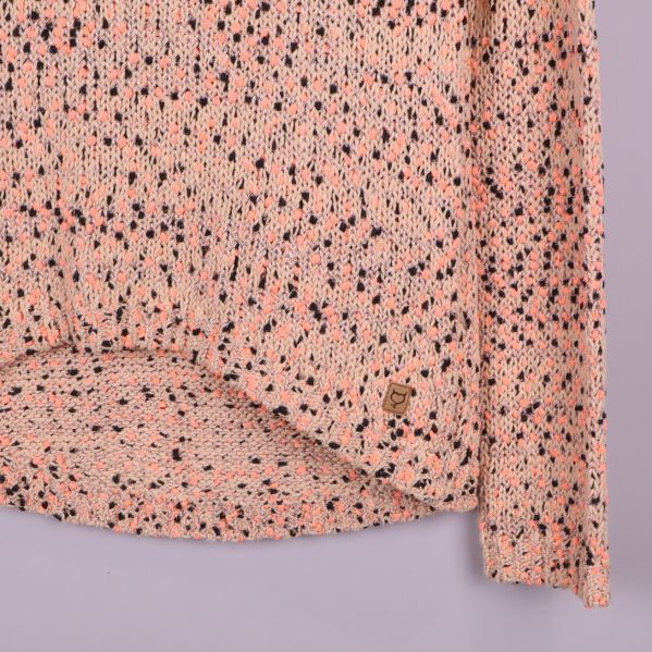 Nederkant på stickad tröja med etikett och asymmetrisk fåll