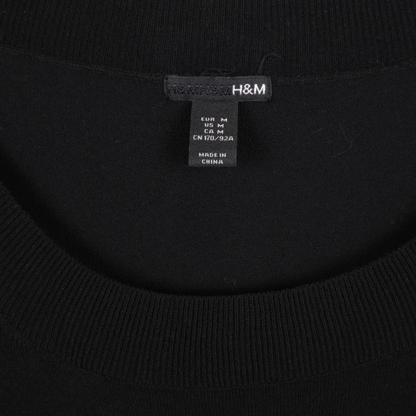 Närbild på H&M-etikett i svart tunika