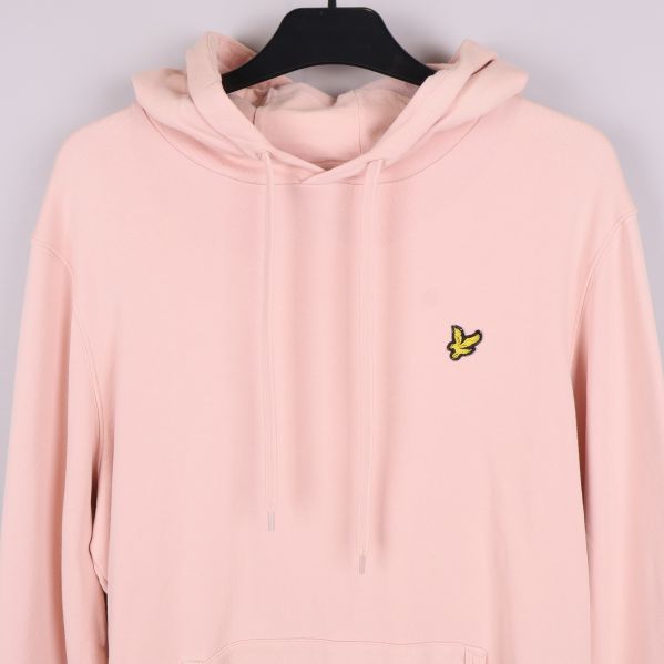 Ljusrosa hoodie med broderad gul logga på bröstet