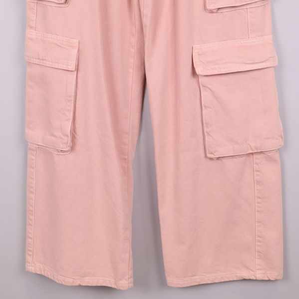 Närbild på ben och stora benfickor i rosa tyg