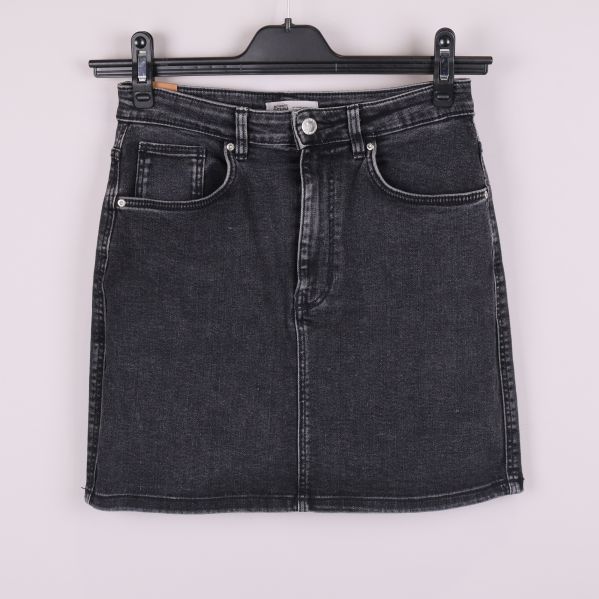 Framsidan av svart denimkjol med fickor