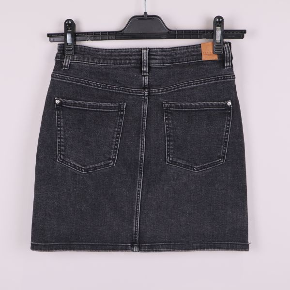 Baksidan av svart denimkjol med bakfickor och hällor