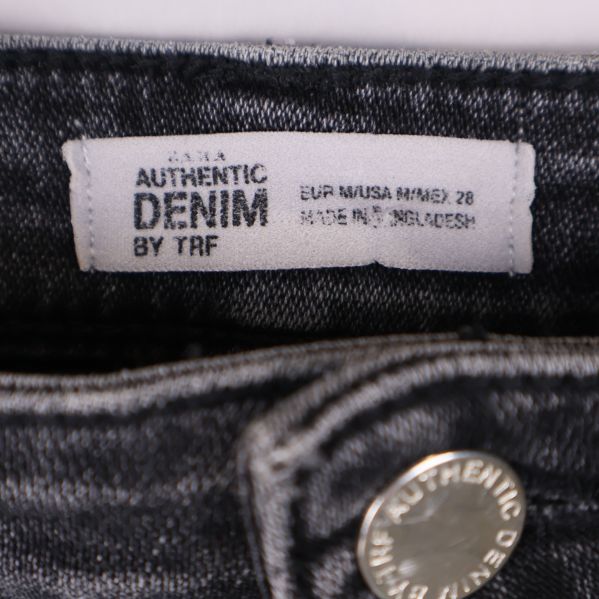 Närbild på varumärkesetikett med texten Authentic Denim by TRF