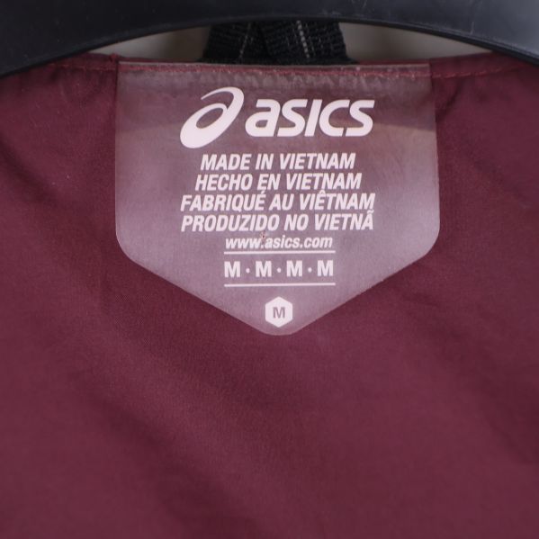 Närbild på Asics etikett och storlekslapp inuti väst
