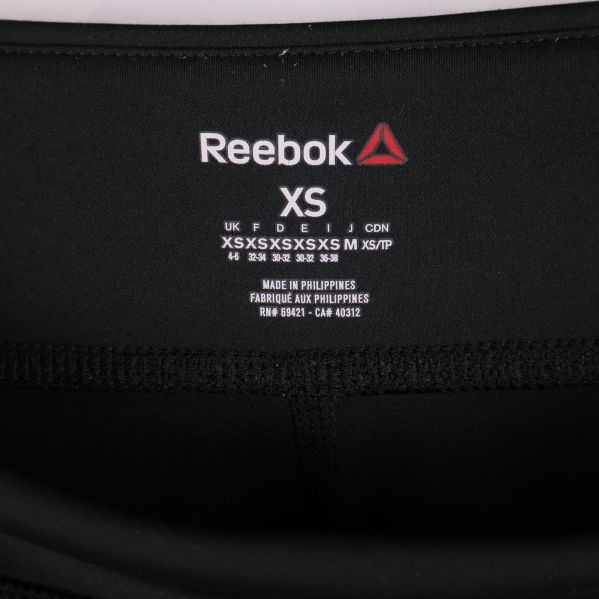 Reebok logotyp och storleksinfo XS på insidan av midjan