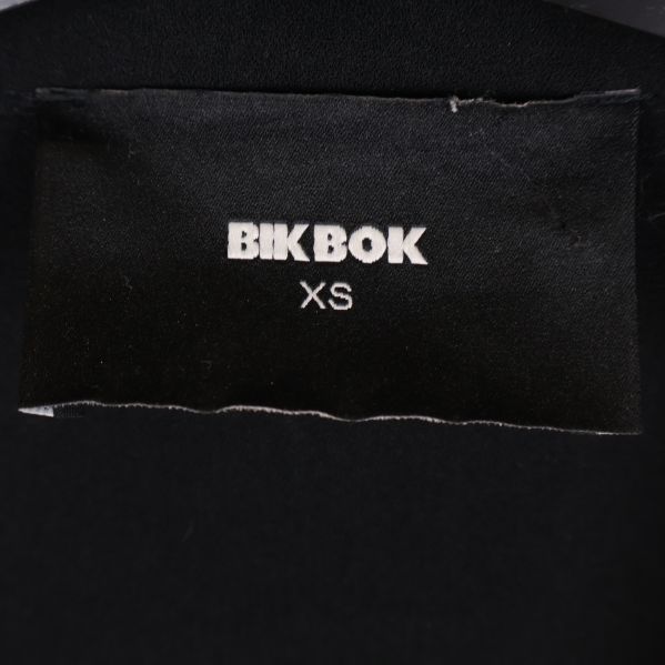 Närbild på Bik Bok-etikett i kappans nacke med storlek XS