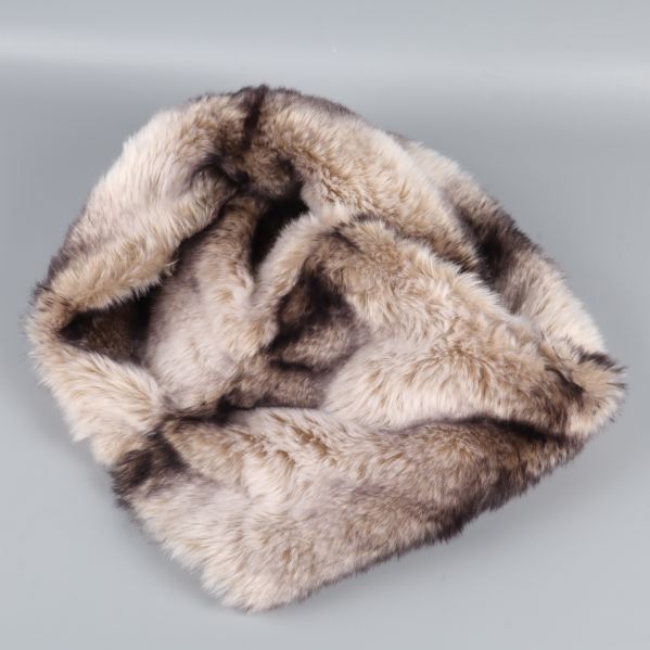 Fuskpäls-halsduk cirkelformad lagd på grå bakgrund