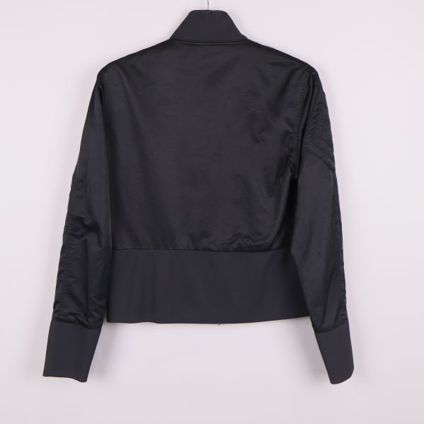 Jackans baksida med slät svart yta och ribbad nederkant