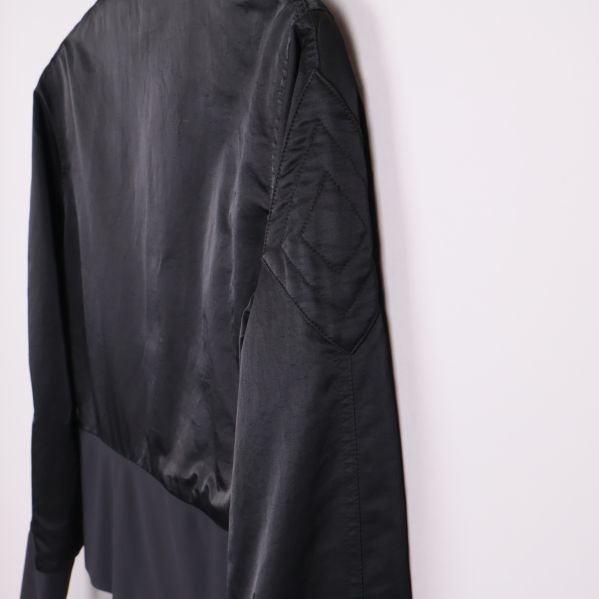 Sidan av jackan med markerad söm och slät svart yta