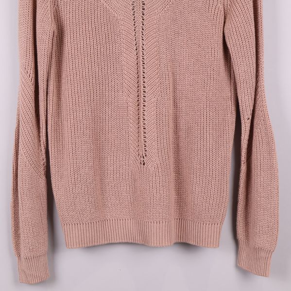 Närbild på ärmar och nederkant av stickad tröja