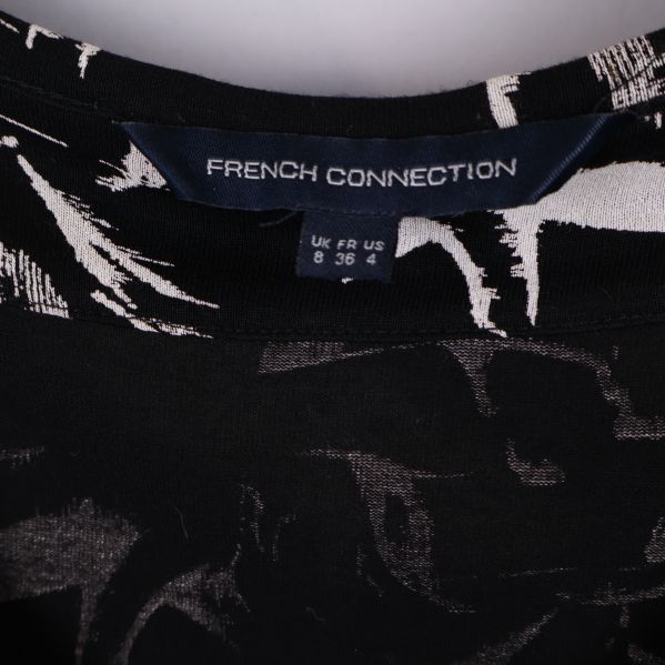 Nära bild på etikett med French Connection logga och storlek