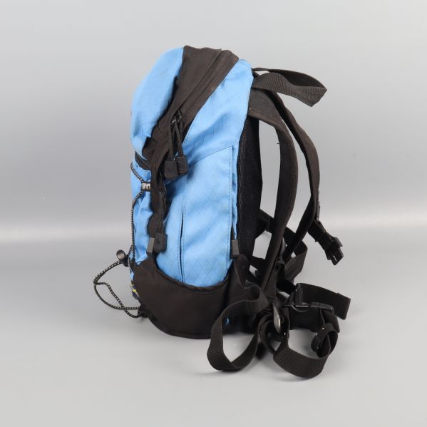 Mini ryggsäck i blått och svart, sedd från sidan