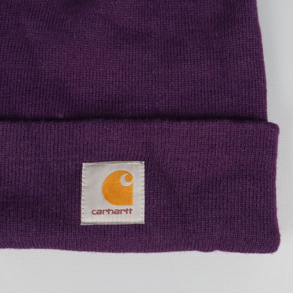 Närbild på Carhartt-logotyp på lila mössa