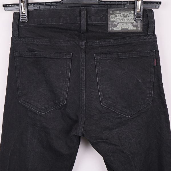 Närbild av bakfickor och midjeetikett på jeansen