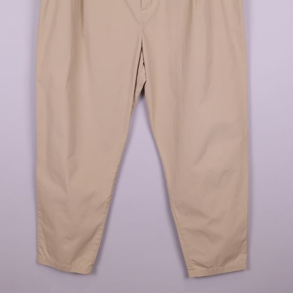 Nedre delen av beige byxa med avsmalnande ben