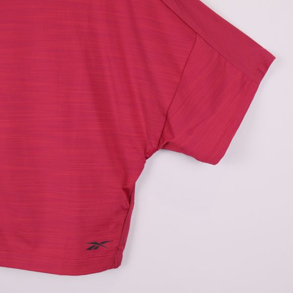 Detalj av höger ärm och Reebok-logga på ceriserosa topp