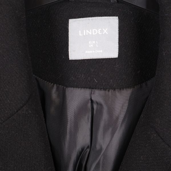 Närbild på Lindex-logotypen i kappans nacke