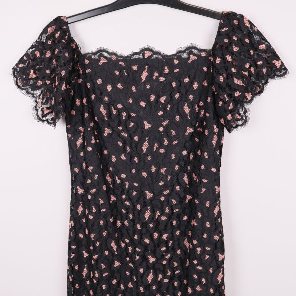 Närbild på klänningens överdel och volangärmar i spets