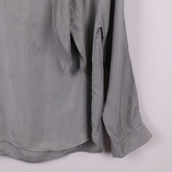 Blusens ärmslut och del av nederkant i närbild