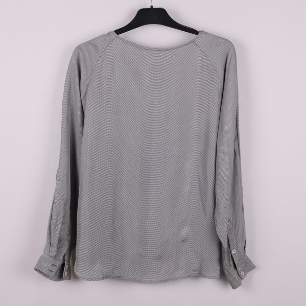 Blusens baksida med långa ärmar på galge