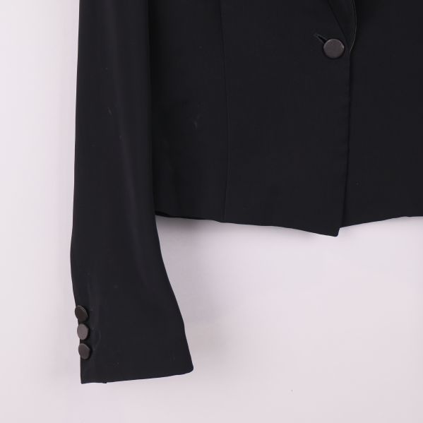 Närbild på ärmslut med dekorativa knappar i svart kavaj