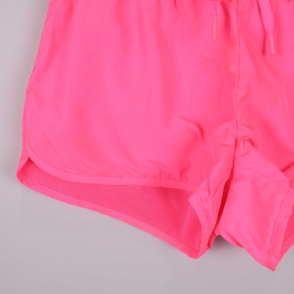 Närbild på benkant och meshinlägg i rosa shorts