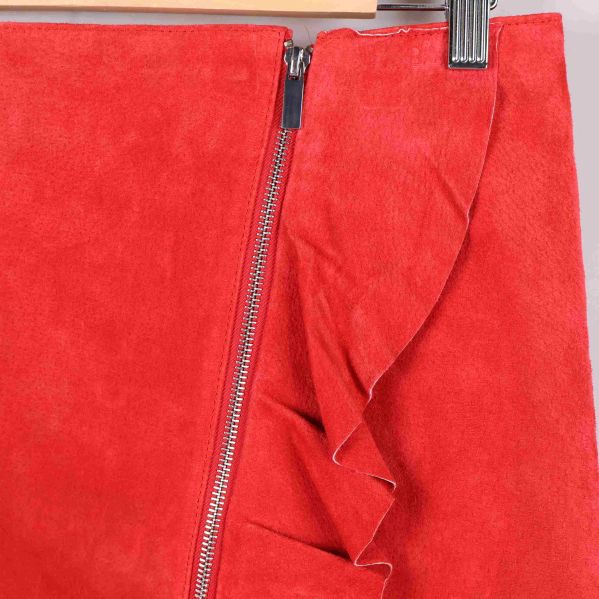 Närbild på dragkedja och volang