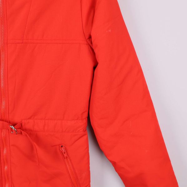 Närbild på vänster ärm och ficka med dragkedja