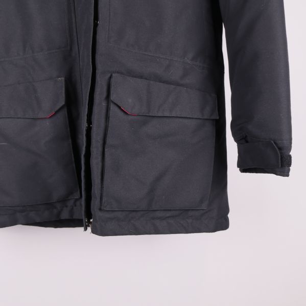 Nedre delen av svart jacka med stora fickor