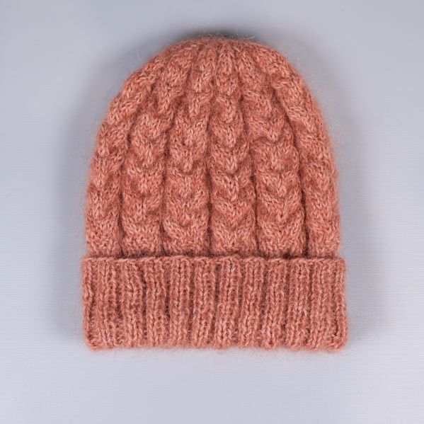 Baksidan av kabelstickad mössa i varm färg
