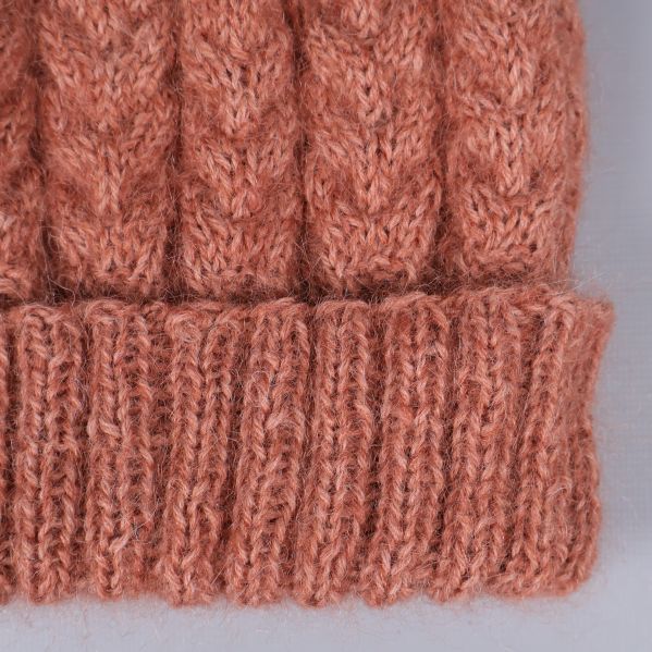 Närbild av uppvikt kant och kabelstickning på mössa