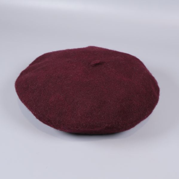 Vinröd basker på vit bakgrund