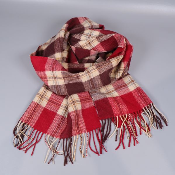 Halsduk i rutig design liggande med fransar synliga