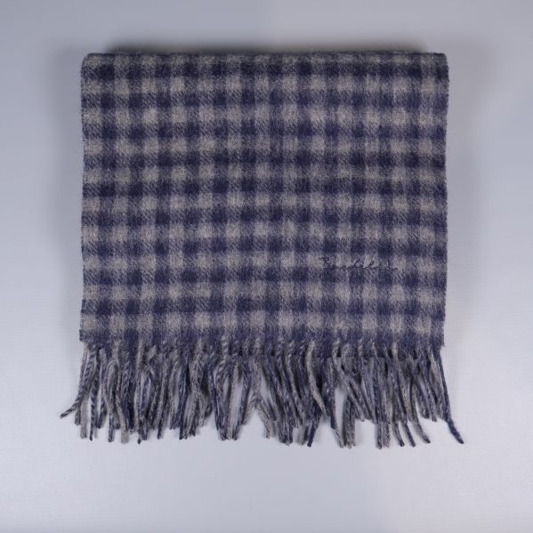 Rutig halsduk med fransar vikt fyrkantigt framför vit bakgrund