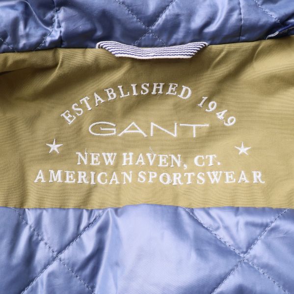 Broderad GANT-text på blått foder i jackan