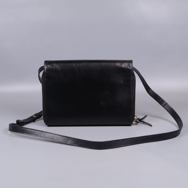 Baksidan av slät svart axelremsväska med lång rem