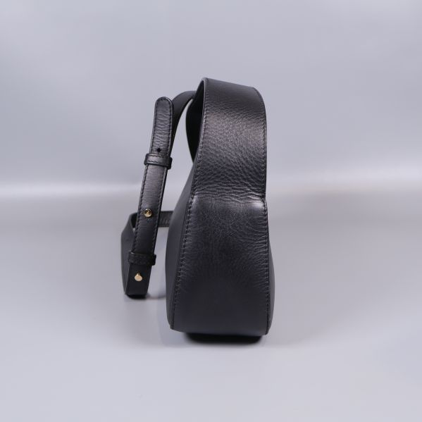 Svart väska sedd från sidan med rem och struktur