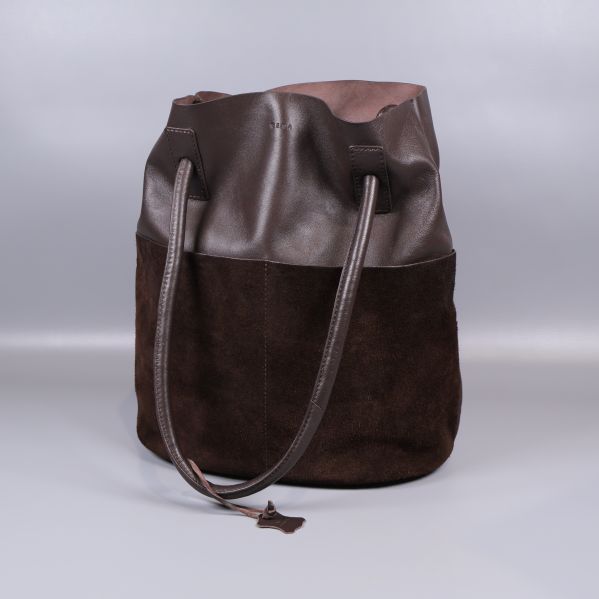 Brun bucketväska med axelband syns i helbild framifrån