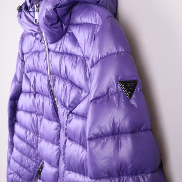 Sidan av lila jacka med GUESS-logotriangel på ärmen