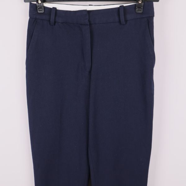 Närbild på midja och framficka av mörkblå byxor