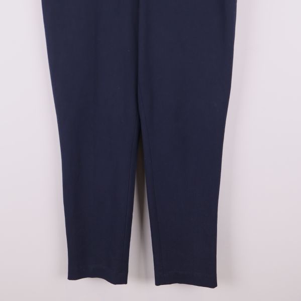 Närbild på benslut av mörkblå byxor med avsmalnande ben