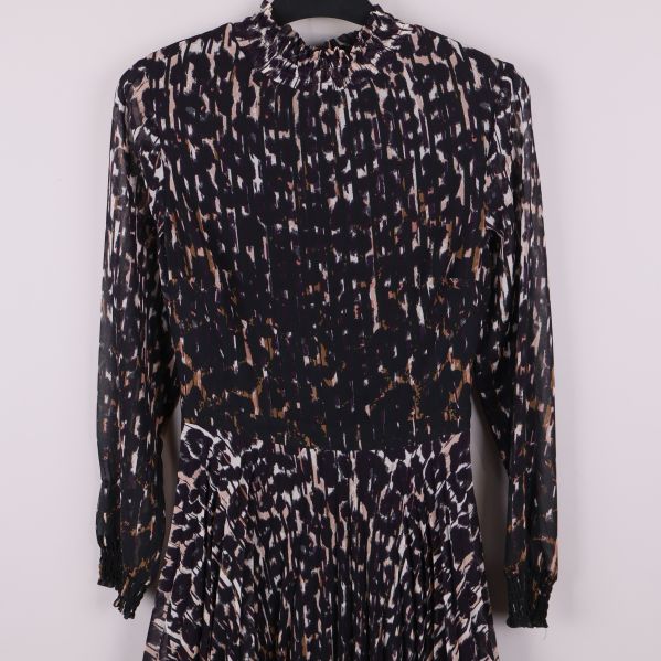 Närbild av klänningsärm och överdel med animaltryck